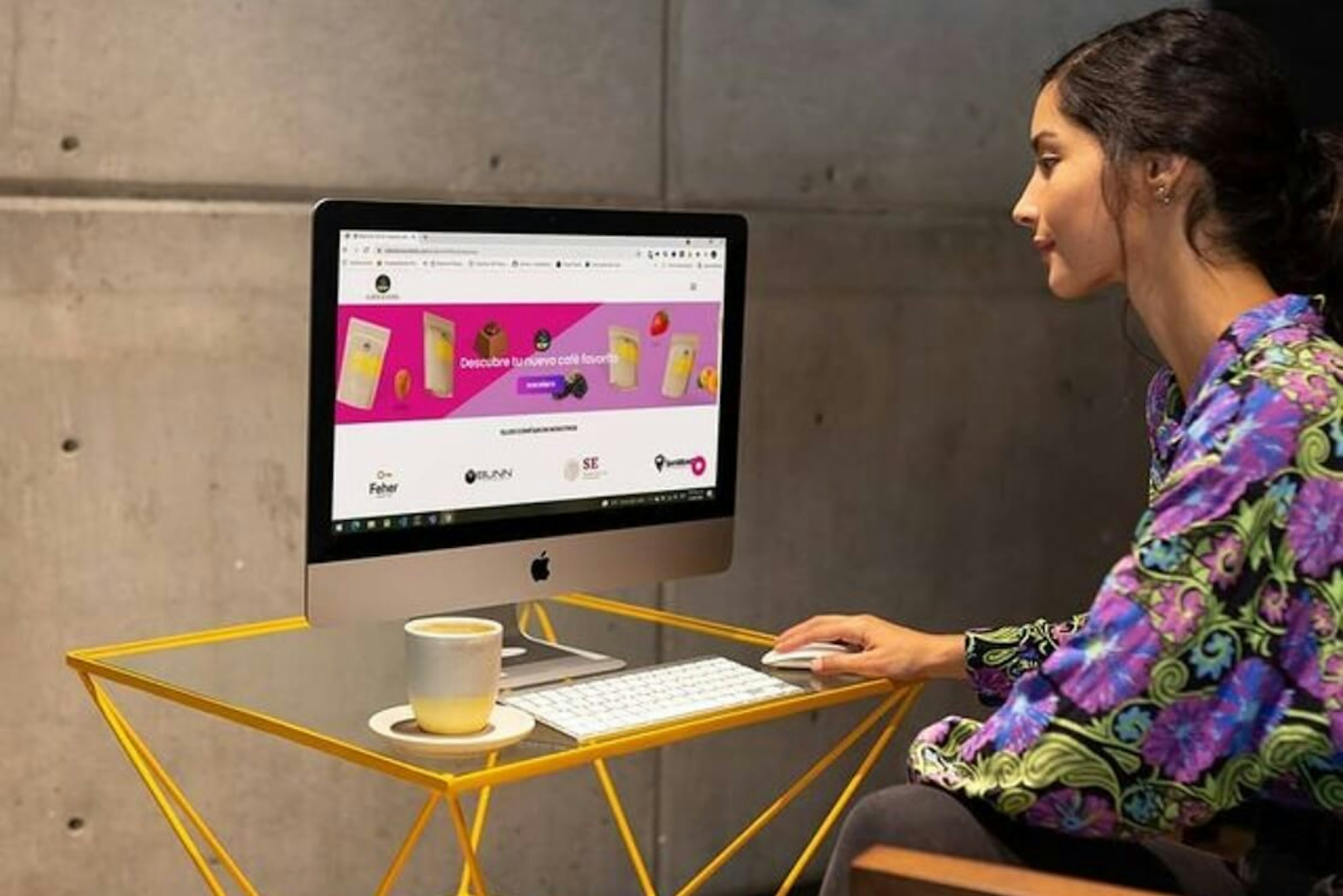 Una mujer observa el sitio web oficial de El Café de los Sentidos donde se ve la suscripción de café que ofrecen. En nuestro taller aprenderás a lanzar un negocio digital de café de la mejor manera posible.
